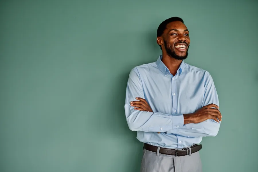 A newly accepted applicant smiling with arms crossed