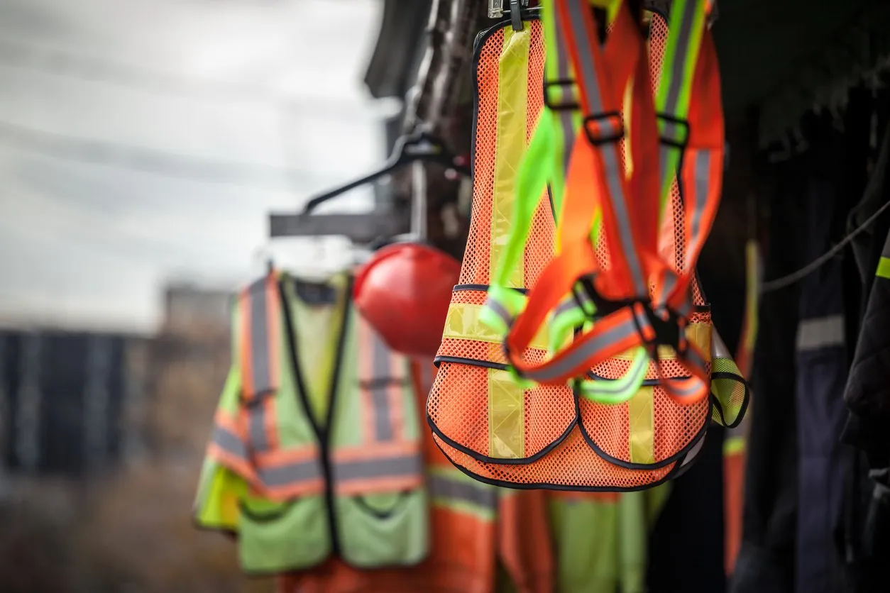 High-visibility vests and hard hats on a training center wall